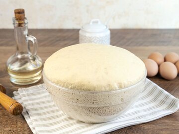 Surowe ciasto drożdżdowe w&nbsp;przezroczystej misce